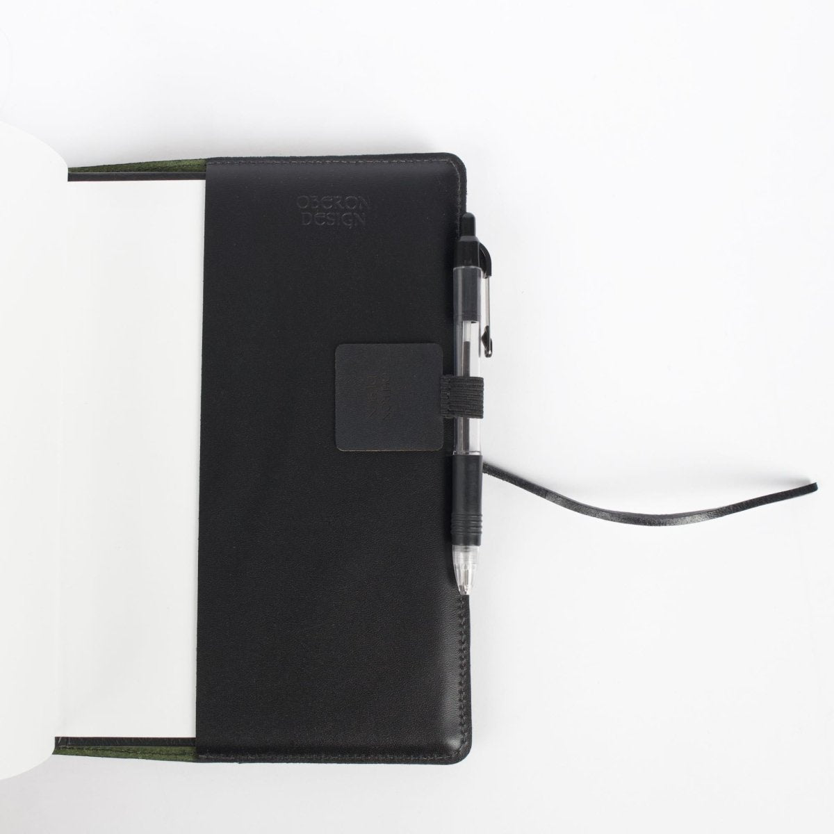 Leather and elastic Self-adhesive Pen Loop in journal open view, by Oberon Design