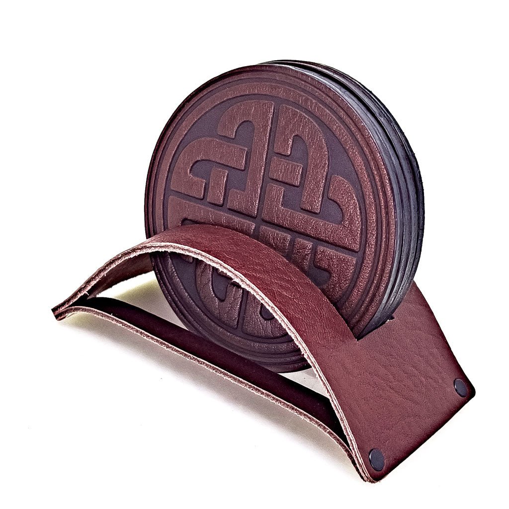 https://www.oberondesign.com/cdn/shop/products/Oberon-Design-Leather-Coasters-Love-Knot-WIne-Group-IN-holder-611385.jpg?v=1697385665